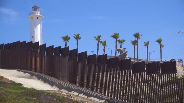 Shot of the border wall and Mexican lighthouse at the San Diego Tijuana fence.