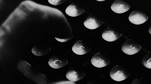 Close-up of hands typing on a vintage typewriter machine. Writing a love letter by the window, 4K black and white.