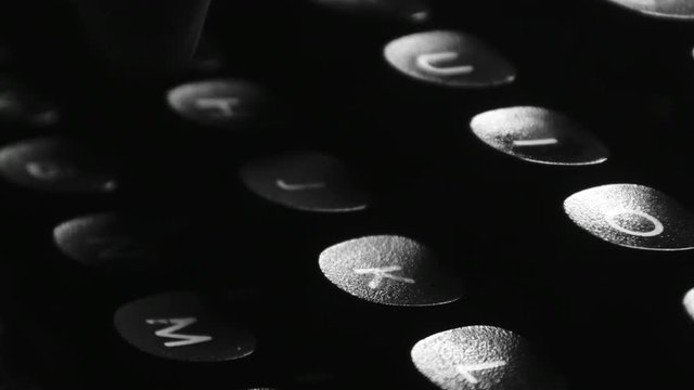 Close-up of hands typing on a vintage typewriter machine. Writing a love letter by the window, 4K black and white.