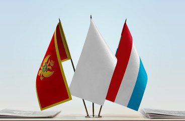 Flags of Montenegro and Luxembourg with a white flag in the middle