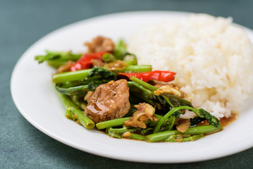 Thai food, stir fried morning glory (Pad Pak Boong) with pork on white dish
