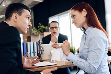 Young red-haired woman tear marriage certificate, looking at indignant man.