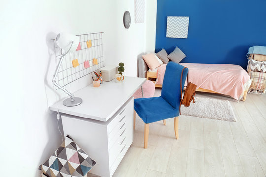 Interior of cozy children's room with table and comfortable bed