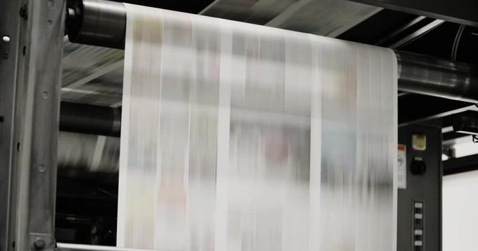 Newspapers move along a conveyor belt at a newspaper factory.