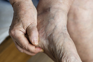 Fototapeta premium Closeup of elderly hand massaging foot