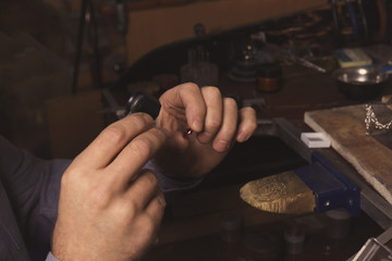 Jeweler examining gem in workshop