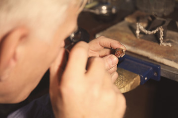 Jeweler examining piece of gold, closeup
