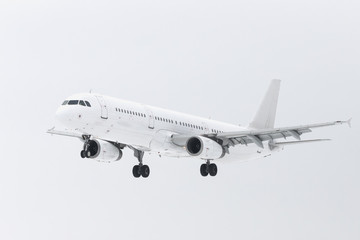 White plane with chassis in the sky, landing mode. Passenger airplane flight