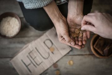 Woman giving money to poor female beggar, closeup