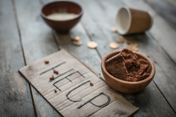 Piece of cardboard with word HELP and food on wooden background. Poverty concept