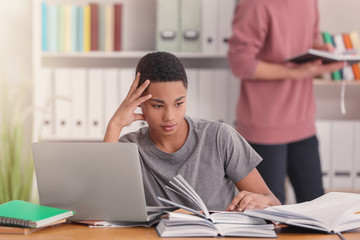 African American teenage boy doing homework at table