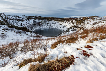 Volcanic crator in winter under cloudy sky