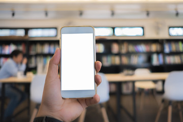 young asian man holding a phone at library