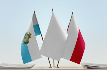 Flags of San Marino and Poland with a white flag in the middle