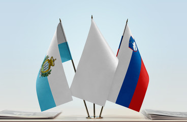 Flags of San Marino and Slovenia with a white flag in the middle