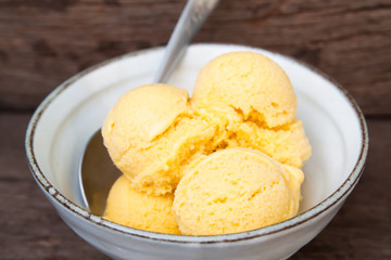 Homemade mango ice cream with milk in ceramic bowl