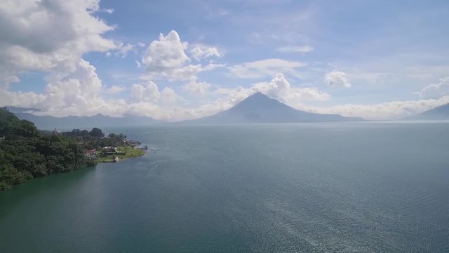Aerial over Lake Amatitlan in Guatemala reveals the Pacaya Volcano in the distance.