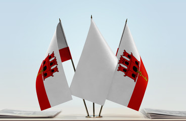 Two flags of Gibraltar with a white flag in the middle