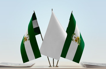 Two flags of Andalusia with a white flag in the middle