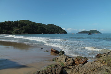 Praia do Engenho, Ubatuba/SP, em dia ensolarado, com &aacute;guas cristalinas, montanhas cobertas por floresta tropical e sem presen&ccedil;a de pessoas, destacando a beleza natural e preservada