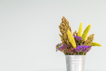 A colorful dry flower on an aluminum bucket with white background.