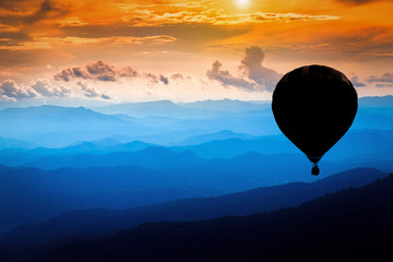  Silhouette Colorful hot air balloons flying over mountains landscape with dramatic sunset sky and clouds