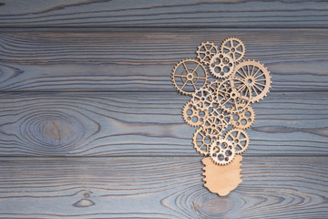 a lamp of gears piled on a wooden table. Business idea of the concept of teamwork, cooperation strategy