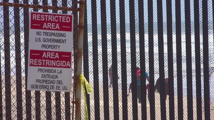 Signs warn of a restricted area at the U.S. Mexico border fence in the Pacific Ocean between San Diego and Tijuana.
