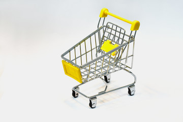 Close the grocery store in the supermarket and push the shopping cart with the yellow handle isolated from the White background. Shop concept