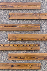 Wooden slats plaques on a granite wall