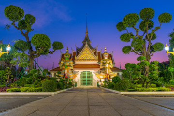 Naklejka premium One of the famous temple in Wat Arun Ratchawararam with two giants statue in the front during twilight time