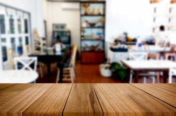 Selected focus empty brown wooden table and Coffee shop or restaurant blur background with bokeh image. for your photomontage or product display.