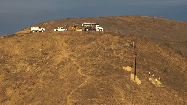 A SCE telephone lineman maintenance crew works on power lines on burned hills following the disastrous Thomas Fire in Southern California.