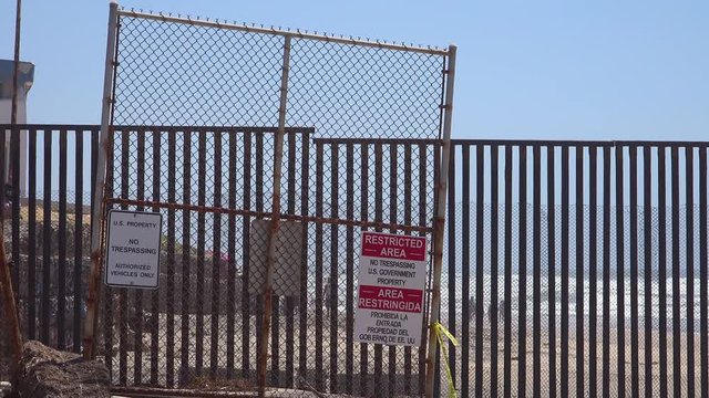Signs warn of a restricted area at the U.S. Mexico border fence in the Pacific Ocean between San Diego and Tijuana.