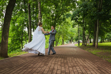 Bride and groom walking in summer park