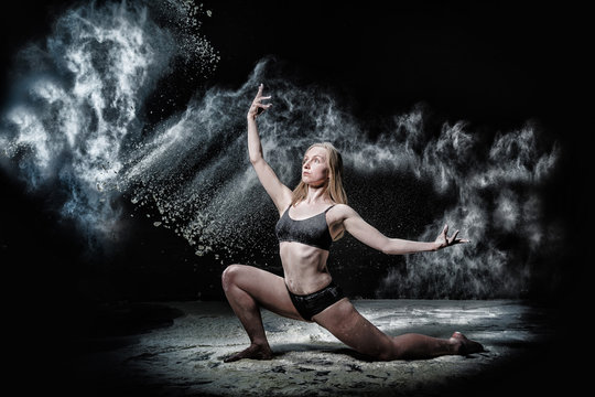 Girl dansing with flour on black background