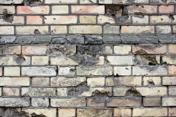 Old brick wall with bullet and grenade marks