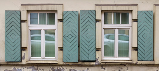 Fototapeta premium Two windows in the old house with open wooden shutters.