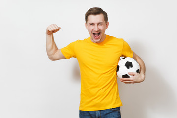 Inspired young European man, fan or player in yellow uniform hold soccer ball, cheer favorite football team, expressive gesticulate hands isolated on white background. Lifestyle concept. Copy space.