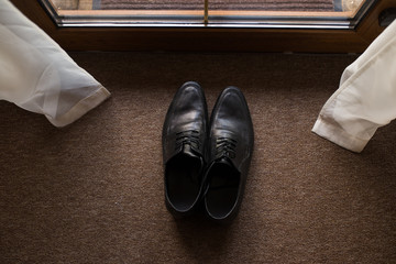 Black men's leather shoes on a brown background. Wedding details.