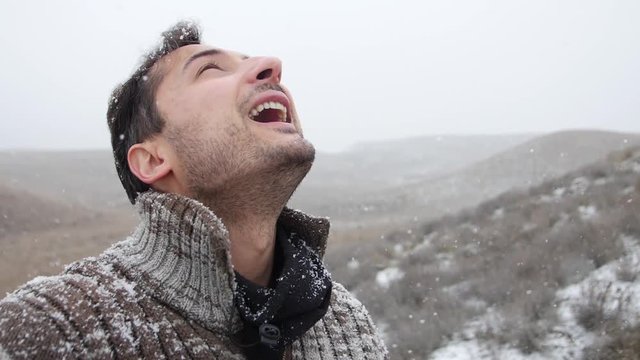 Adult man is happy to snowfall. Head is look up