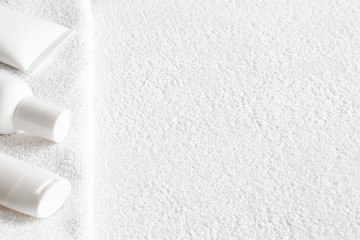 Different, white beauty toiletries for men, women, kids on towel. Mock up for special offers as advertising. Cares about clean and soft hands, legs, feet and body skin. Empty place for text or logo. 