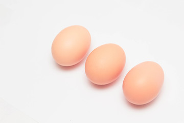 three chicken eggs on a white background