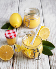 Lemon curd in glass jar with fresh lemons