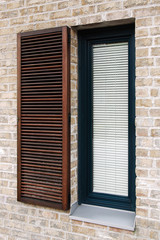 Blinds in modern window, Detail on modern brick facade with wooden window with shading elements, Contemporary narrow window with metal parapet