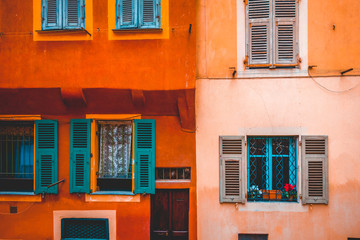 ancient facade in orange and rose colors with green windows