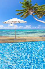 Fototapeta na wymiar piscine au parasol, fond lagon seychellois 