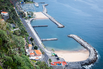 Man-made bay with beaches, resort houses during sunny day in Calheta, Madeira, Portugal