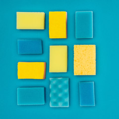 top view of yellow and blue washing sponges isolated on blue