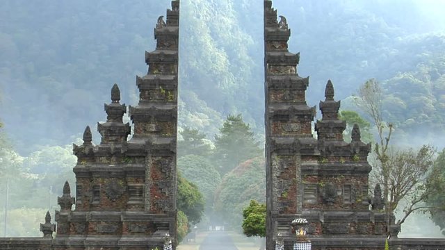 The fog drifts by a traditional Balinese temple gate in Bali, Indonesia.
